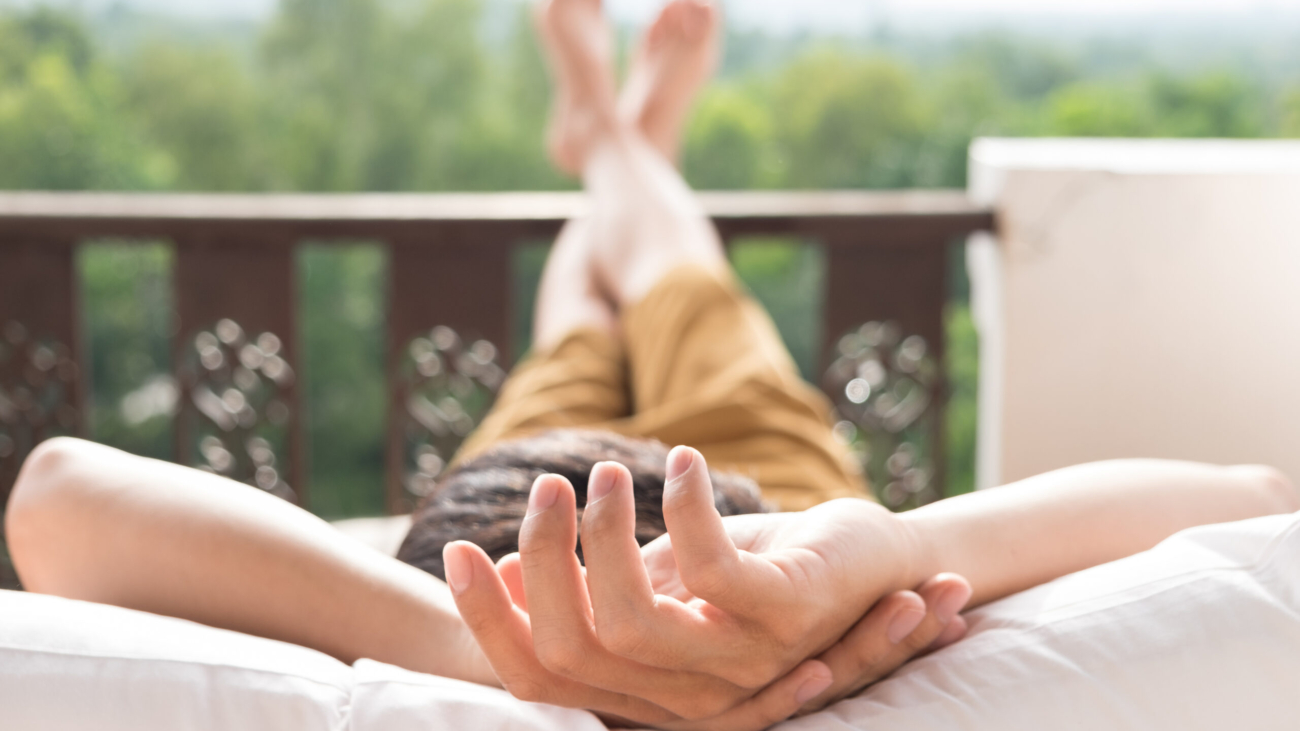 Young man relax on bed and enjoying mountain view.